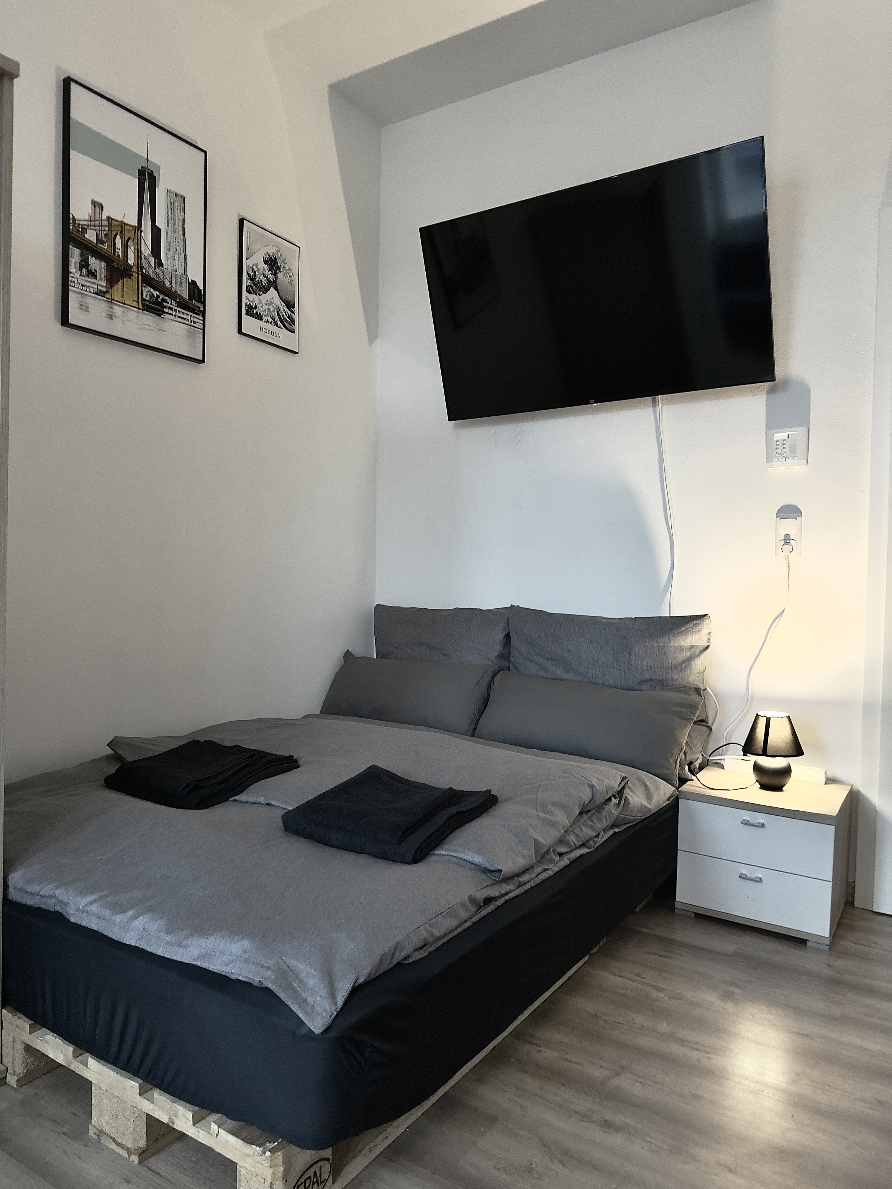 Wohnung 21 – Doppelbett mit Stadtfotos und Smart TV